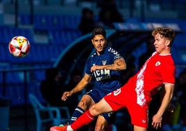 Los universitarios luchan por el balón durante el partido contra el Sevilla Atlético.