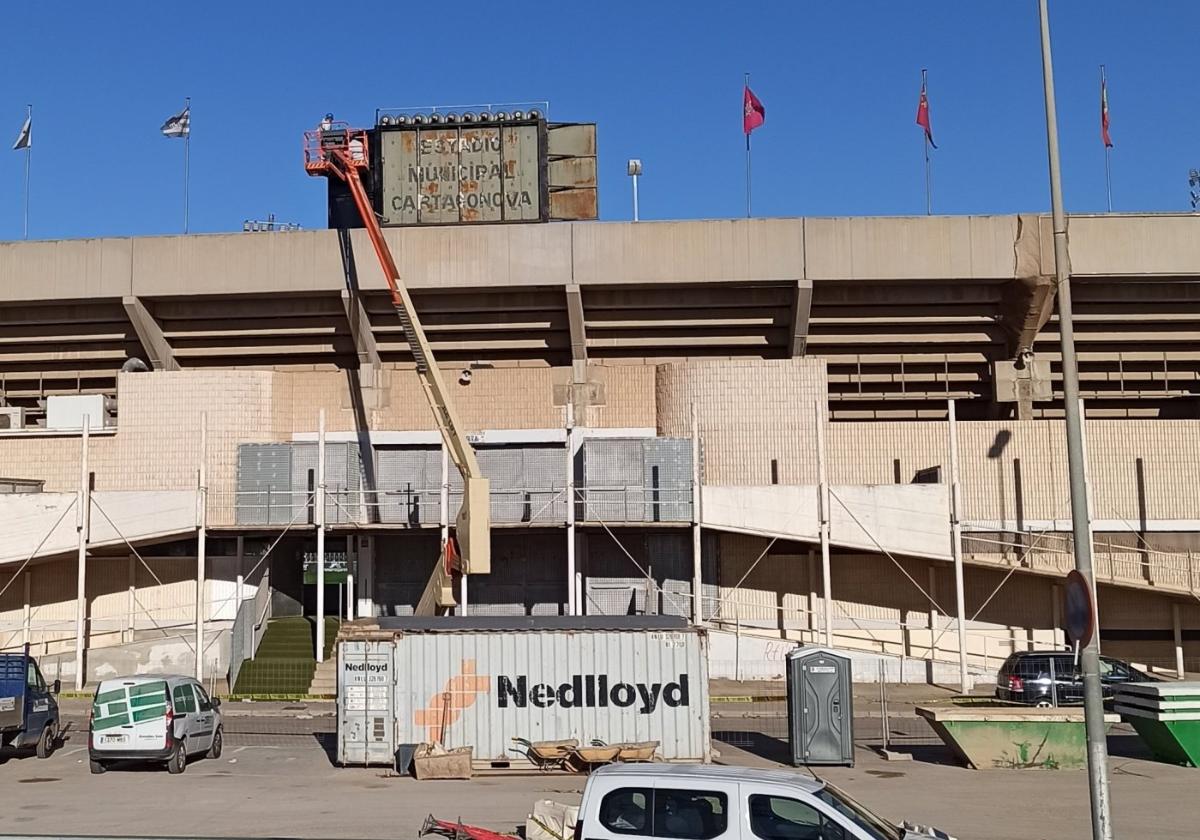 Un operario retira el óxido del videomarcador del estadio Cartagonova, antes de proceder a pintarlo de negro.