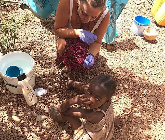 Lola intenta realizar una cura en la pierna de Kadilla, durante su viaje a Senegal.