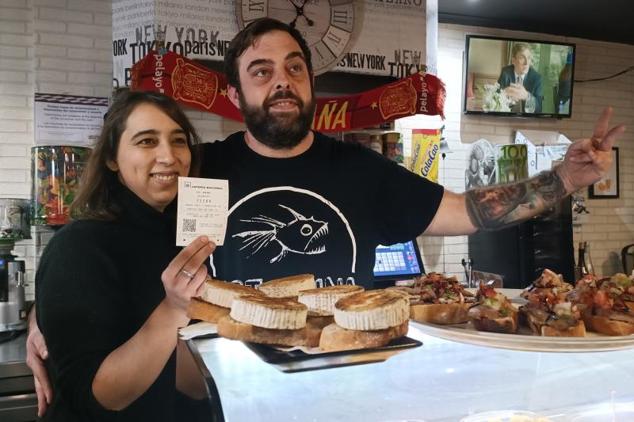 Sandra y David posan con un décimo del 72.289, agraciado con el segundo premio de la Lotería de El Niño, este viernes tras haberlo adquirido horas antes del sorteo en la terminal de su bar en Villamayor de Gállego.