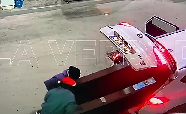 Los presuntos atracadores introducen la máquina de tabaco en el vehículo. 