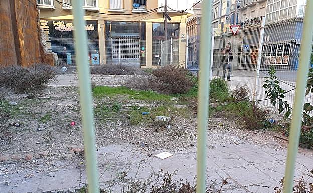 Solar con matorrales y suciedad en la plaza del Risueño con calle Duque. 