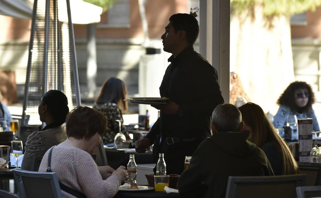 Un camarero atiende a los clientes en una terraza en Murcia. 