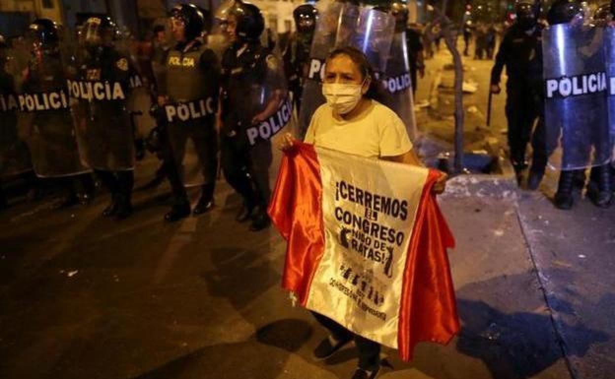 Una manifestante reclama en Lima el cierre del Congreso.