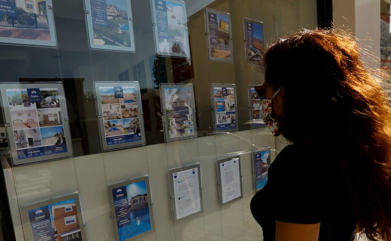 Una mujer observa anuncios en una inmobiliaria de Murcia. 