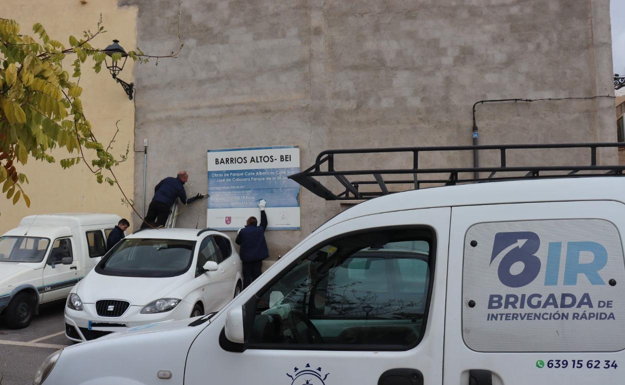 Operarios de la Brigada de Intervención Rápida retiran un cartel del parque de La Mujer. 