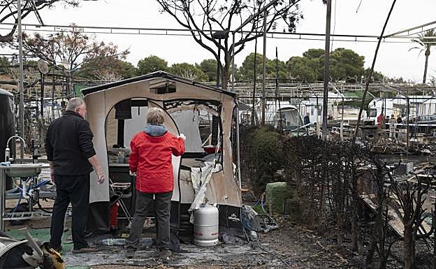 Dos afectados por el incendio revisan los restos de su caravana este martes. 