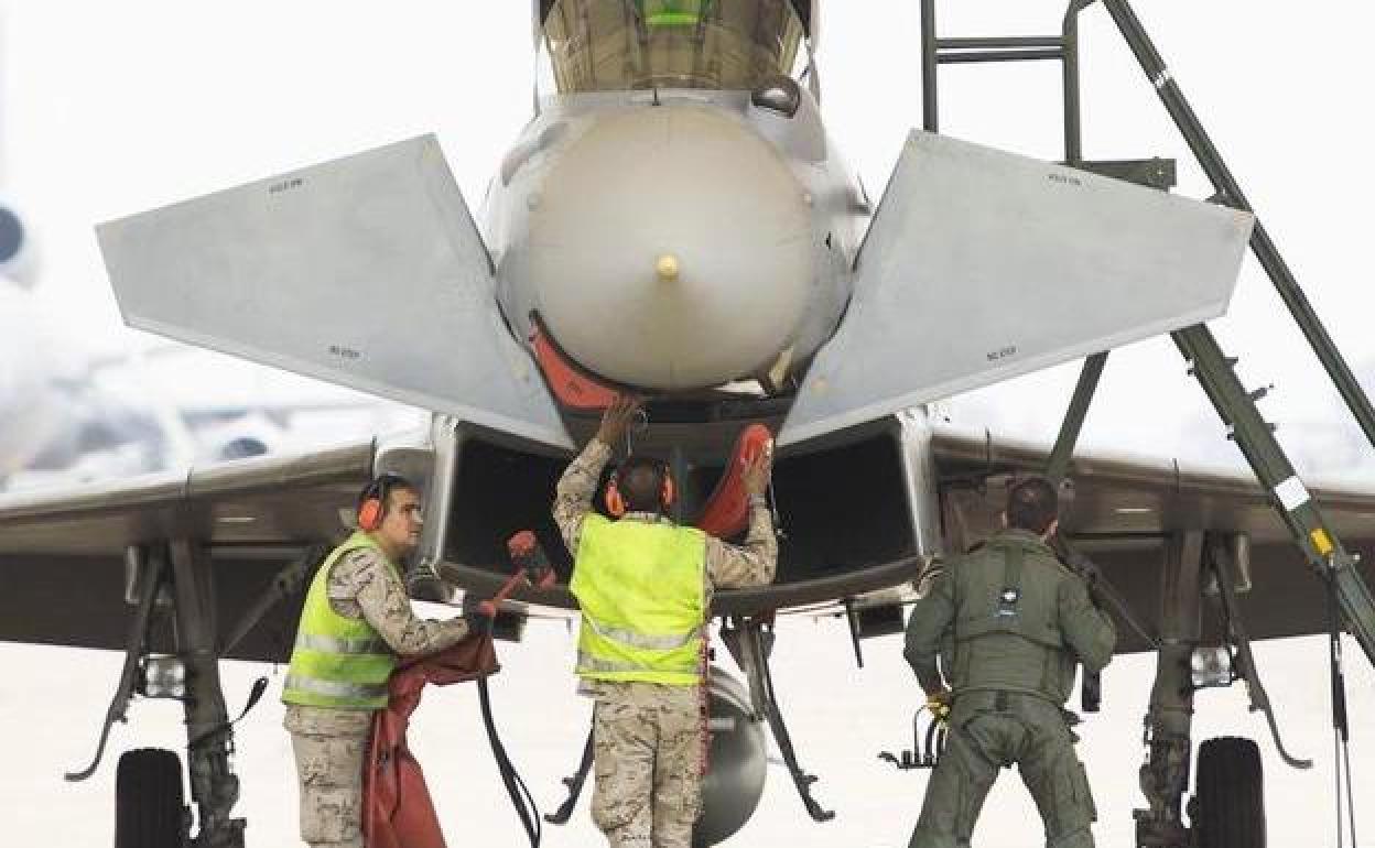 Varios operarios preparan el despegue de un avión Eurofighter en la base aérea de Morón de la Frontera, en Sevilla