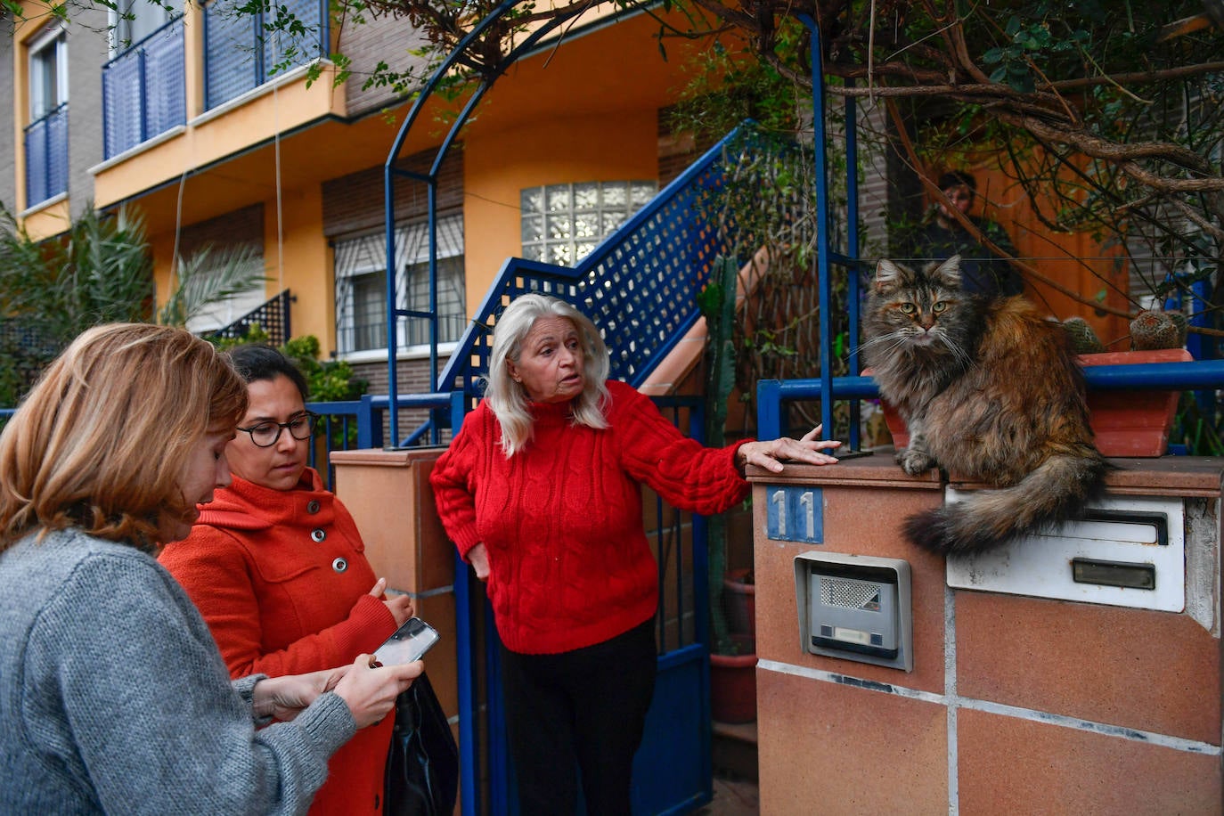 Voluntarias explican a una vecina de Monteagudo cómo debe alimentar a los gatos comunitarios. 