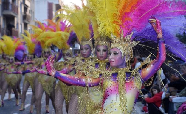 Several members of a troupe show off their colorful feathered outfits during the third parade. 