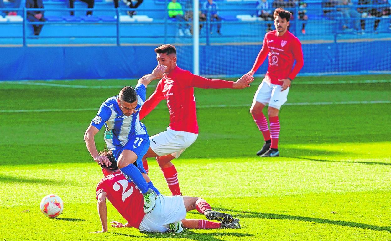 El local Cristo Martín es entrado en falta por Palmera, lateral de La Unión, ayer en El Rubial. 