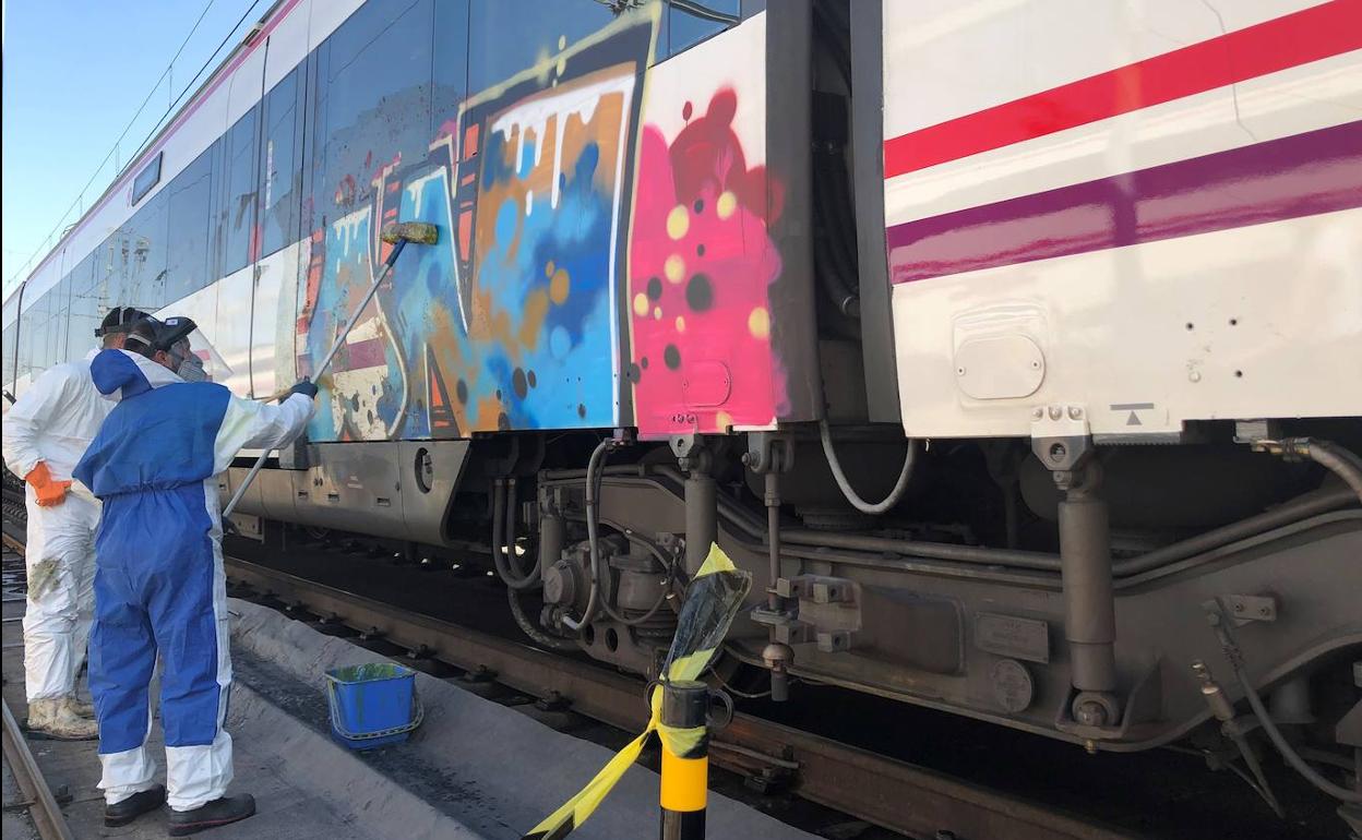 Trabajadores de Renfe limpian un vagón pintado por grafiteros.