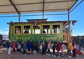 Niños junto al 'vagón real' que visita las pedanías para que entreguen sus cartas.