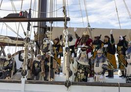 Los Reyes Magos saludan a las personas que les esperan en el puerto antes de desembarcar.