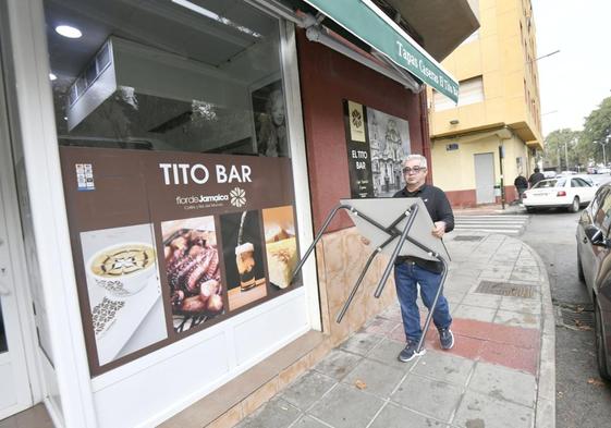 Cristóbal Ayllón, encargado de El Tito Bar, de Vistalegre, traslada una de las mesas dentro local tras desmantelar la terraza.