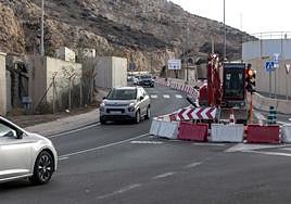 Un coche espera, mientras otros pasan, junto a las obras de construcción de la senda hasta Cala Cortina, a la altura de San Leandro.