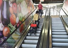 Clientes bajan con la compra por las escaleras paradas.
