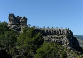 El castillo de Benizar desde el flanco oeste, con la muela coronada por la torre del homenaje y los almendros sobre la meseta.