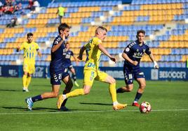 Juanmi Callejón, jugador del Orihuela, intenta jugar presionado por Jorge García, del UCAM.