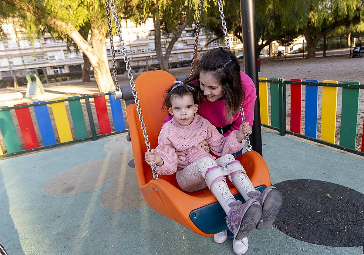 Georgina sube a Claudia en el columpio adaptado del parque Pocoyó.