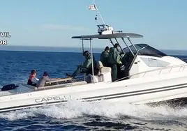 La Guardia Civil junto a los dos hombres detenidos en una embarcación.