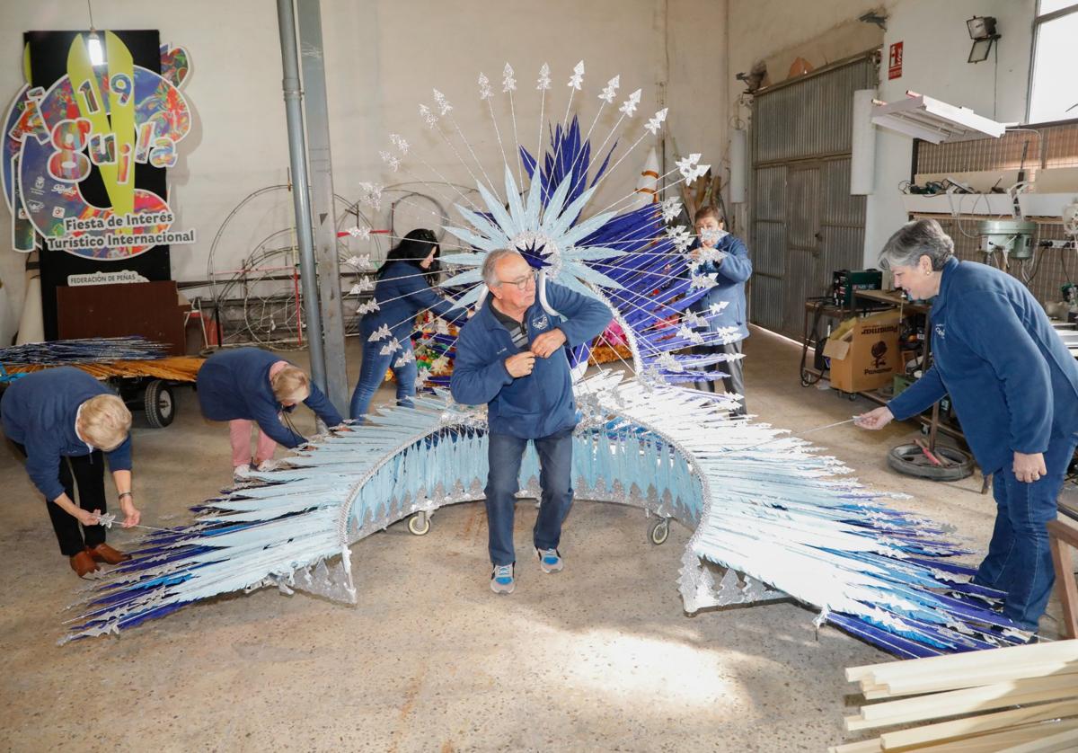 Miembros del taller de trajes de papel del Carnaval de Águilas repasan uno de los carros que sacarán en el desfile de mañana.