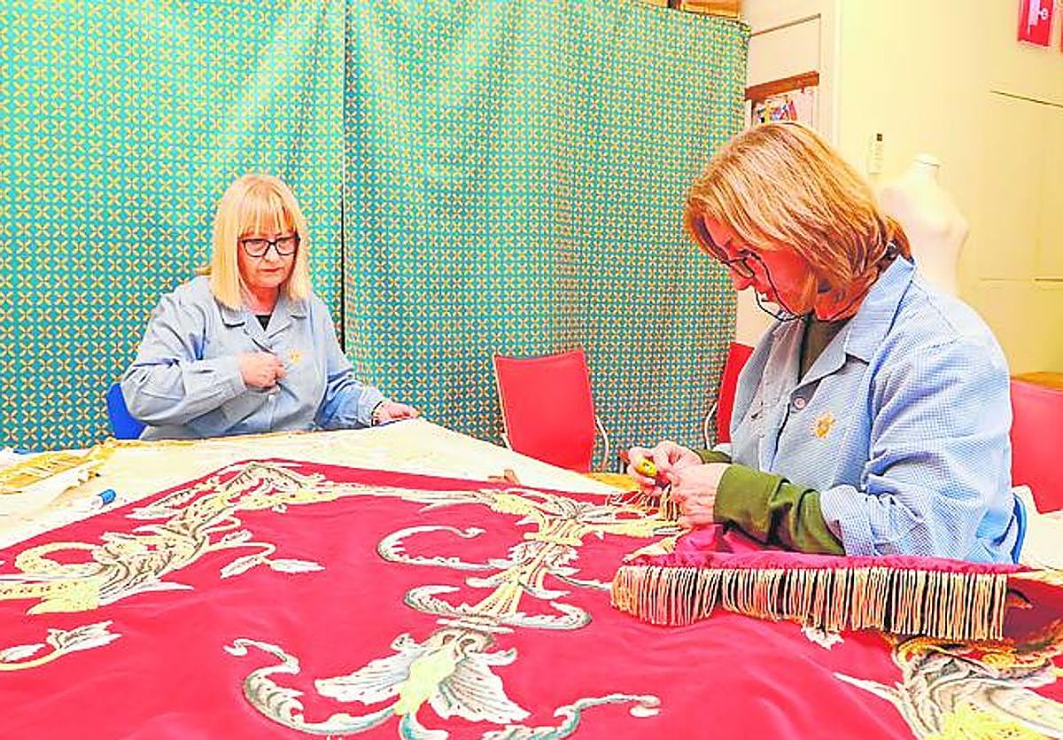 Costureras del Paso Azul rematan los flecos de un manto.