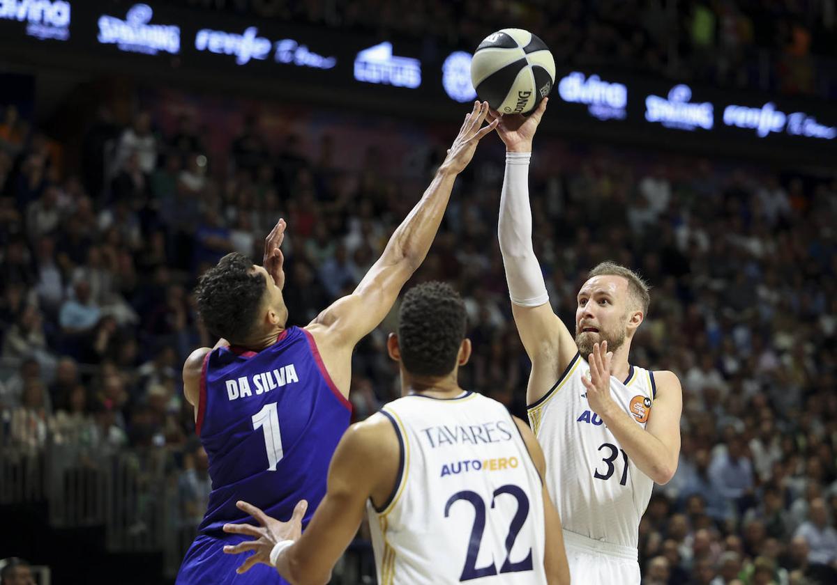 El ala-pívot del Barça Óscar Da Silva lucha con el bosnio Dzanan Musa, del Real Madrid.