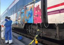 Trabajadores de Renfe limpian un vagón pintado por grafiteros.