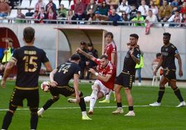 José Ángel Carrillo, delantero del Real Murcia, golpea el balón rodeado de jugadores del Intercity en el partido del pasado domingo.