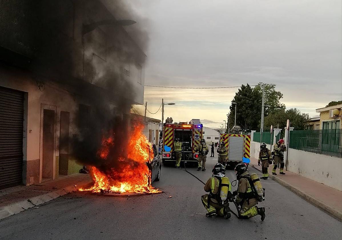 Bomberos apagan el fuego del vehículo.