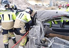 Los bomberos tratan de liberar al conductor.