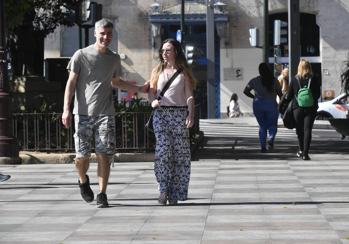 Dos viandantes, en manga corta por el centro de Murcia, en pleno mes febrero.