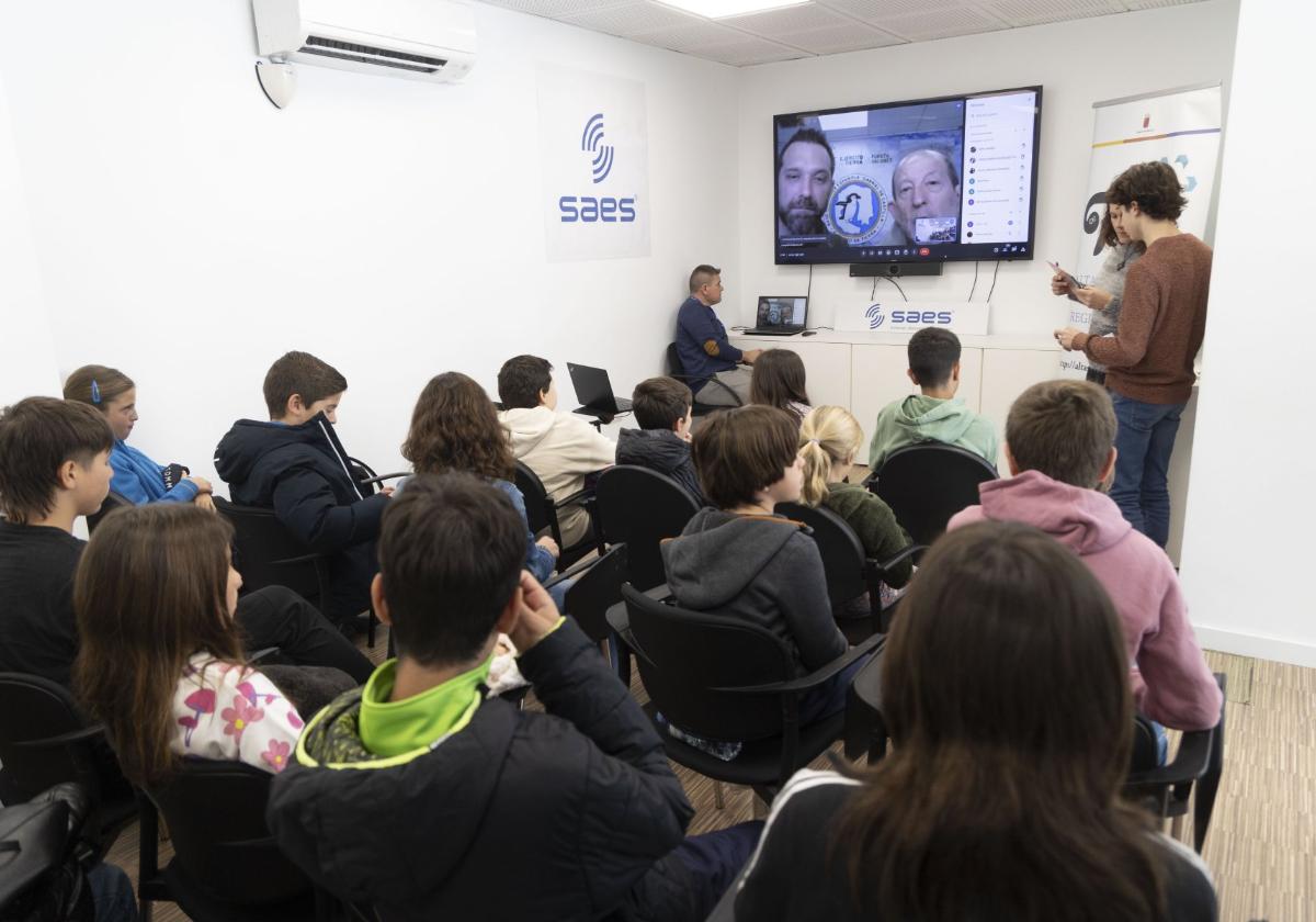 Los alumnos escuchan por videoconferencia a los científicos.