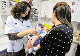 Una enfermera vacuna a un bebé en Murcia.