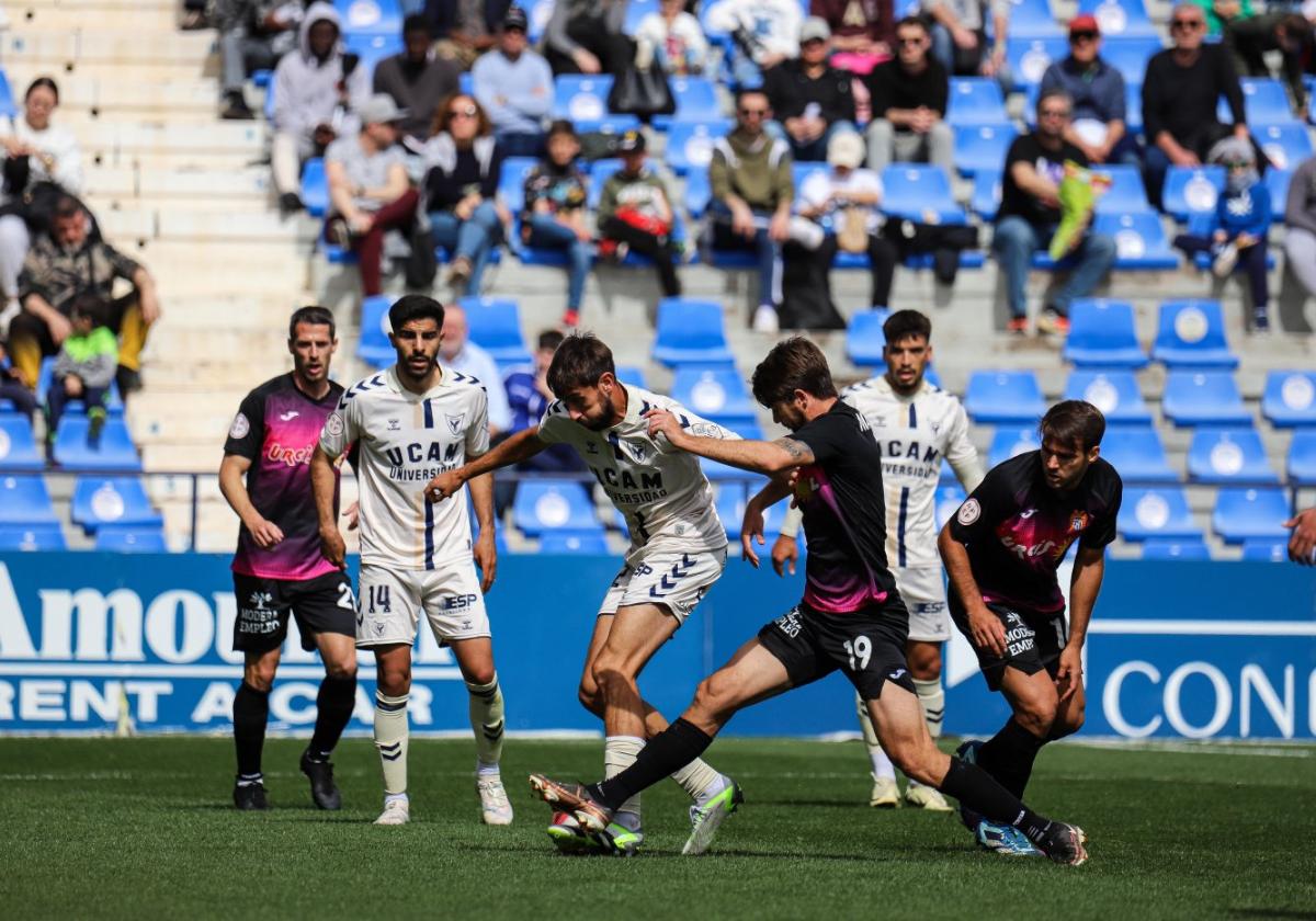 Jorge García, jugador del UCAM, protege la pelota ante Abenza, del Águilas.