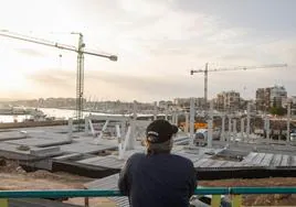Un hombre observa el avance de las obras del nuevo centro de ocio del puerto de Torrevieja muy cerca del lugar por donde se comunicará el nuevo edificio con el paseo del dique de Levante.