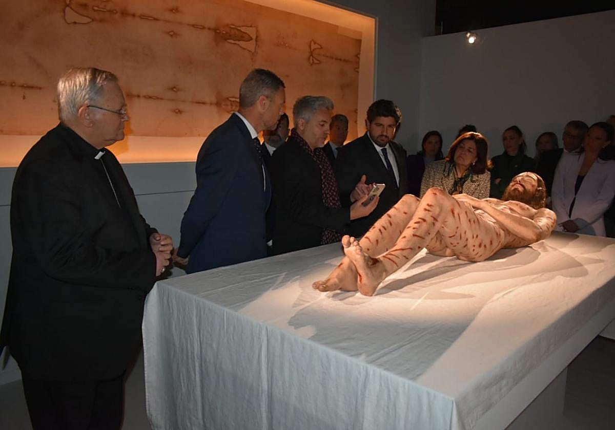 Autoridades contemplando la escultura hiperrealista.