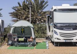 Una mujer extranjera toma el sol junto a su caravana en la parcela que tiene alquilada en el Camping Mar Menor, ubicado entre La Ribera y Los Alcázares.