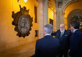 Tomás Sáez muestra al alcalde y al president de la Generalitat el escudo de la Fundación.