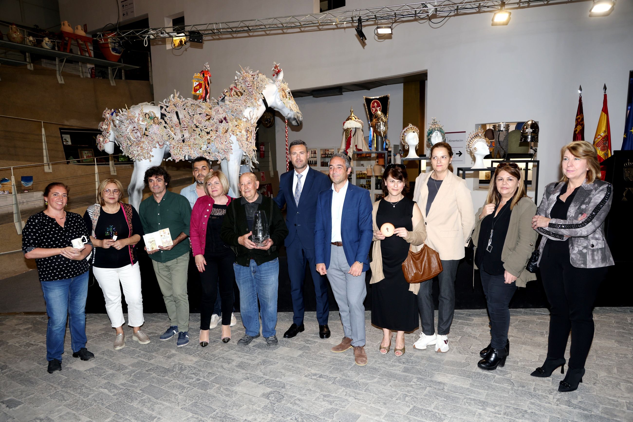 El alcalde y el director general posan con algunos de los artesanos participantes en la exposición.