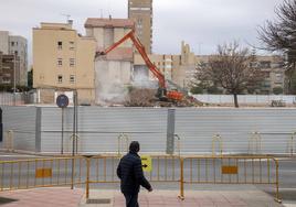 Un hombre camina frente a los trabajos de derribo del cuartel.