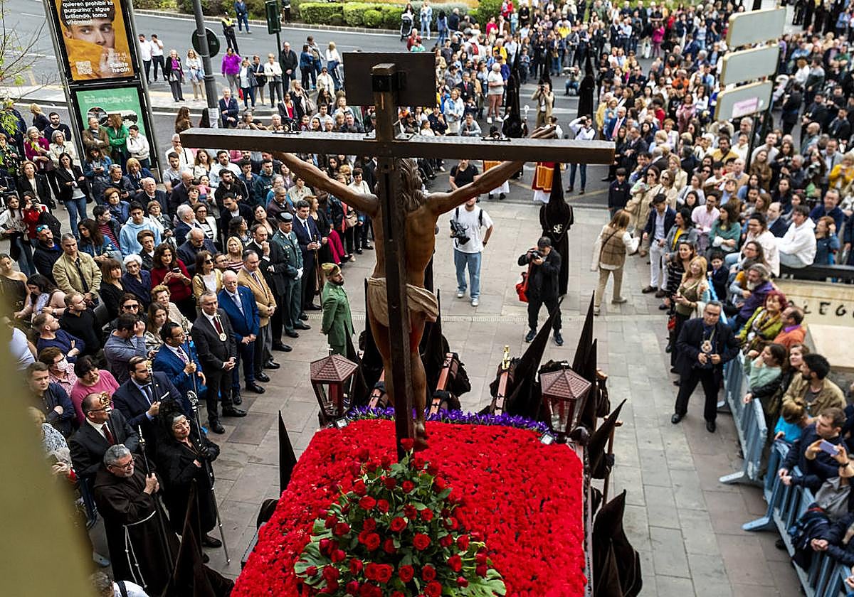 El trono con la imagen del Cristo de la Fe abandona la iglesia de San Francisco de Asís admirado por un nutrido grupo de fieles y autoridades.