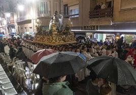 El trono sampedrista de la Imposición del Primado se abre sitio entre los paraguas, en sentido contrario al de la procesión, por la calle del Aire.