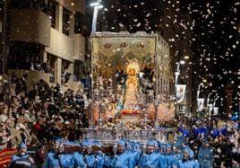 La Virgen de los Dolores, titular del Paso Azul, avanza por la carrera bajo una lluvia de pétalos.