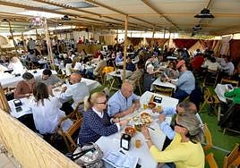 Comensales en la barraca de la peña Los Güertanos, instalada justo a la entrada del Malecón, antes de la tormenta.
