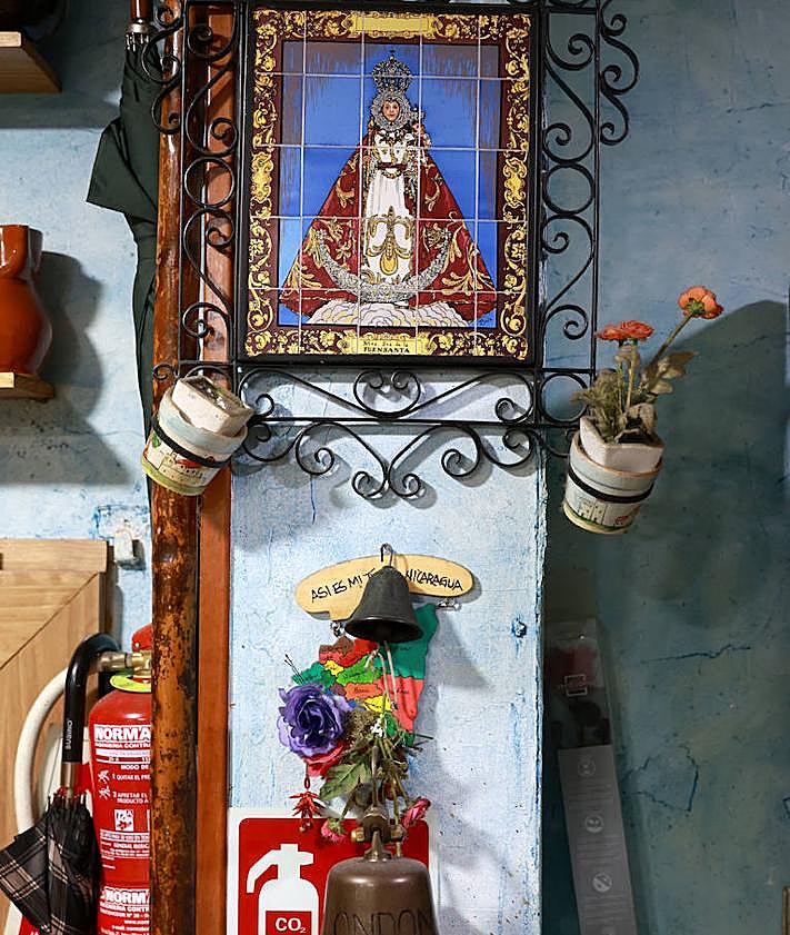 Imagen secundaria 2 - 1. Manuel tiene jarras procedentes de decenas de países, desde Brasil a Tailandia. 2. Imagen de la Virgen de la Fuensanta, flores y extintor contra incendios, no válido para los fuegos bucodentales.