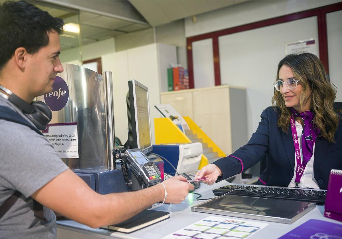 Trabajadora de Renfe atiende a un cliente.