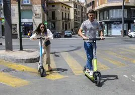 Dos usuarios del servicio de alquiler de patinetes circulando por Murcia, en una foto de archivo.
