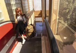 Dos viajeras suben a pulso sus maletas por una de las escaleras mecánicas que no funcionan en la estación de autobuses.